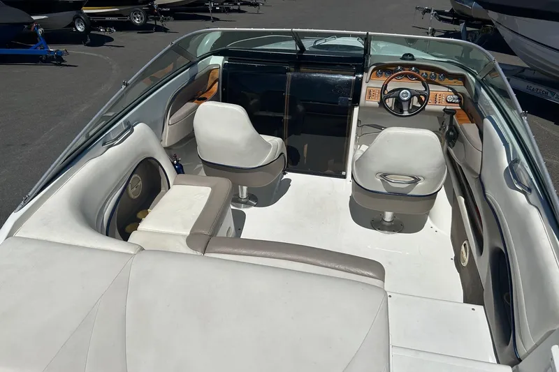 Slide: The Image of Interior of a 2001 Cobalt 227 boat with white seating and wooden dashboard. - 7