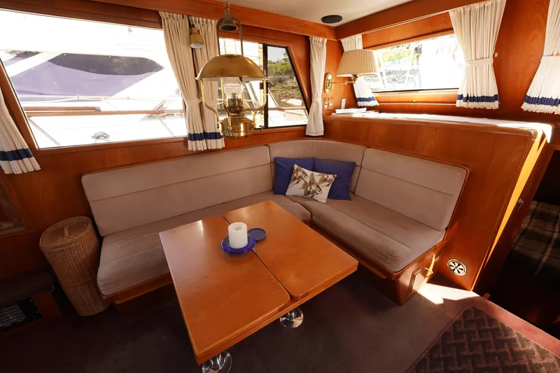 Slide: The Image of 1986 Ocean Alexander 40 Double Cabin interior with cozy seating and elegant wooden table. - 13