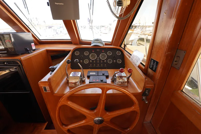 Slide: The Image of 1986 Ocean Alexander 40 Double Cabin helm with wooden wheel and control panel. - 16