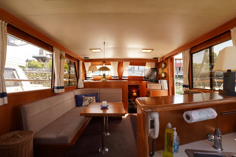 Slide: The Image of Interior of 1986 Ocean Alexander 40 Double Cabin yacht, featuring cozy seating and elegant wood finishes. - 21