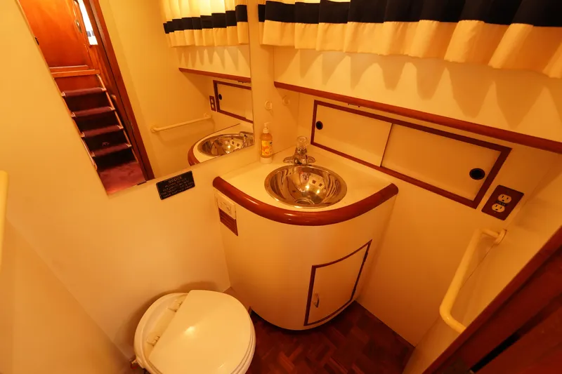 Slide: The Image of 1986 Ocean Alexander 40 Double Cabin bathroom with sink, mirror, and toilet. - 24