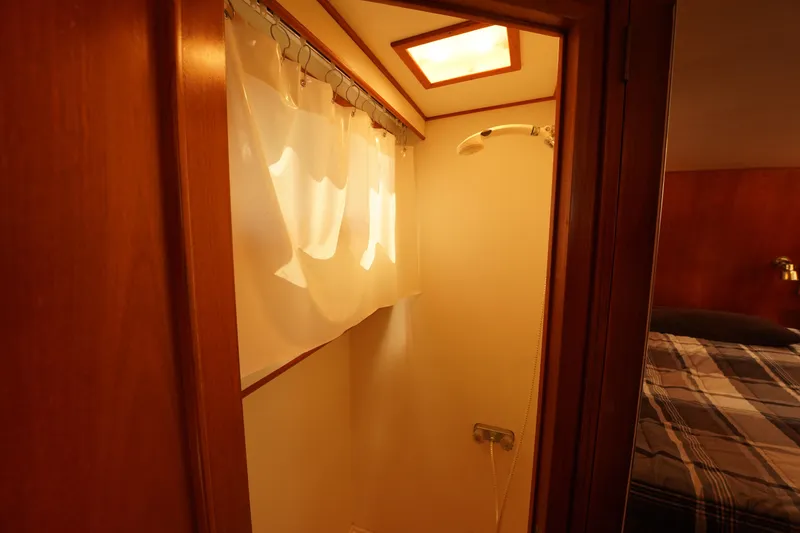 Slide: The Image of Shower area in 1986 Ocean Alexander 40 Double Cabin yacht with curtain and wooden accents. - 25