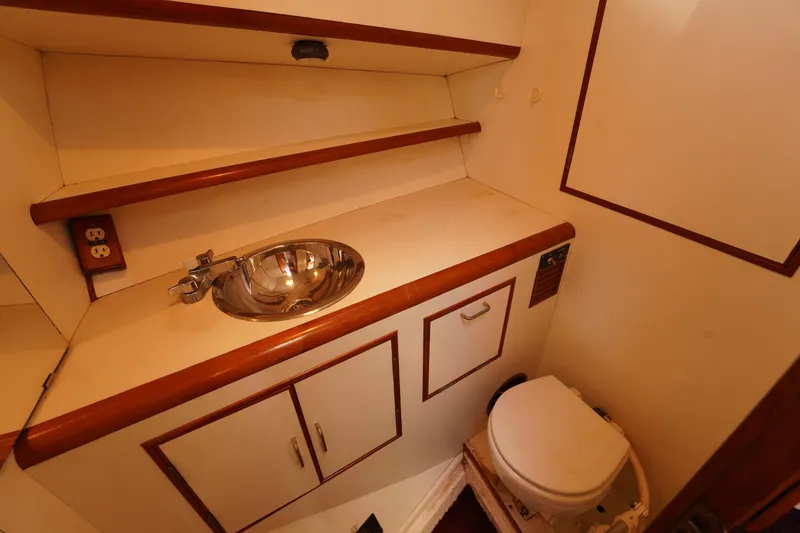 Slide: The Image of 1986 Ocean Alexander 40 Double Cabin bathroom with sink, toilet, and wooden accents. - 20