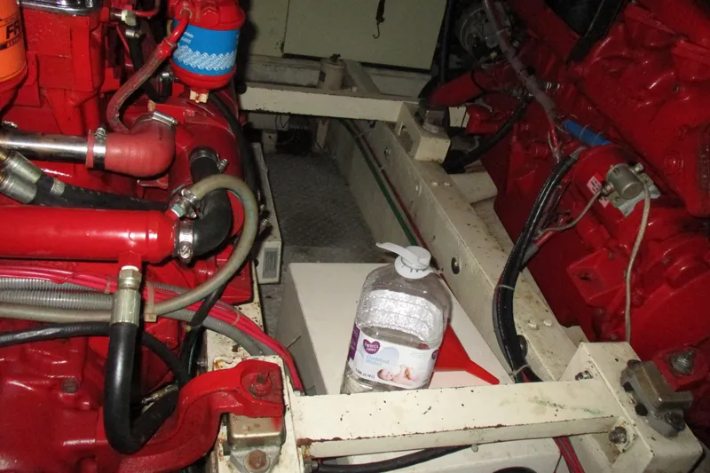 Slide: The Image of Engine room of 1986 Ocean Alexander 40 Double Cabin with red machinery and a water bottle. - 36