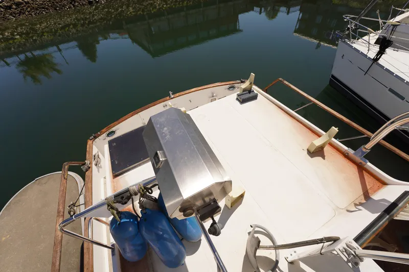 Slide: The Image of 1986 Ocean Alexander 40 Double Cabin yacht deck with grill and blue fenders. - 6