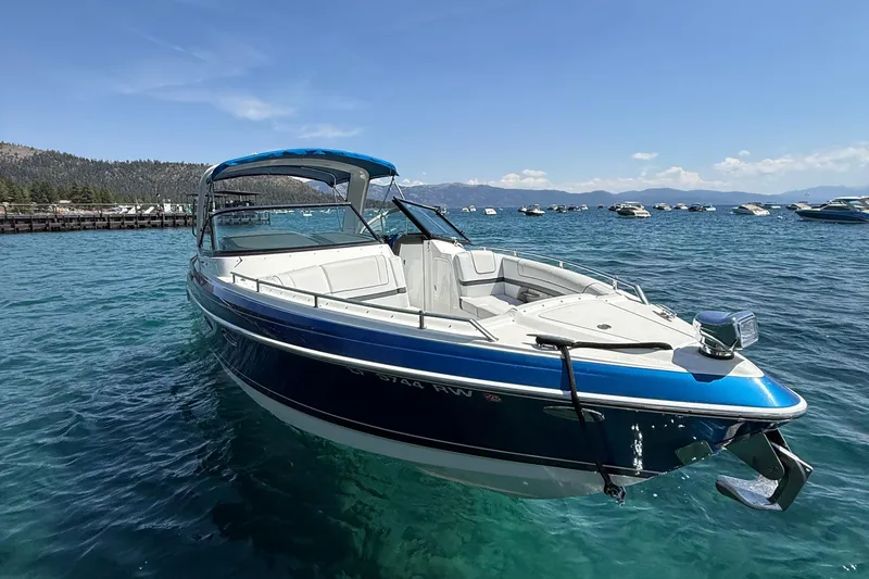 Slide: The Image of 2018 Formula 330 Crossover Bowrider on clear blue water, surrounded by scenic mountains. - 1