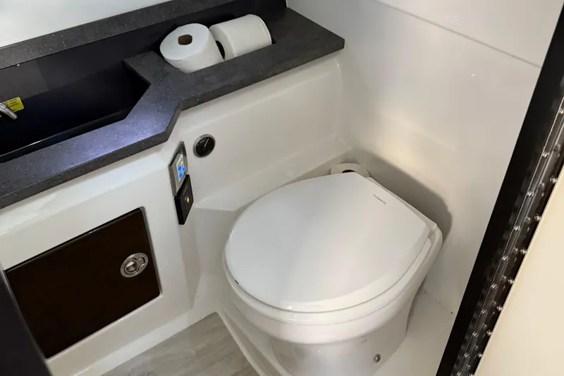 Slide: The Image of 2018 Formula 330 Crossover Bowrider bathroom with toilet, sink, and storage cabinet. - 12