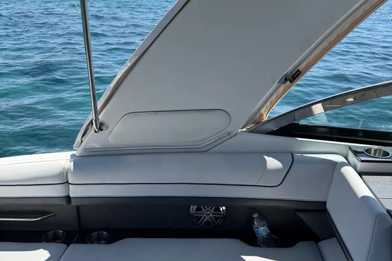 Slide: The Image of 2018 Formula 330 Crossover Bowrider interior with open storage, cup holder, and water bottle. - 4