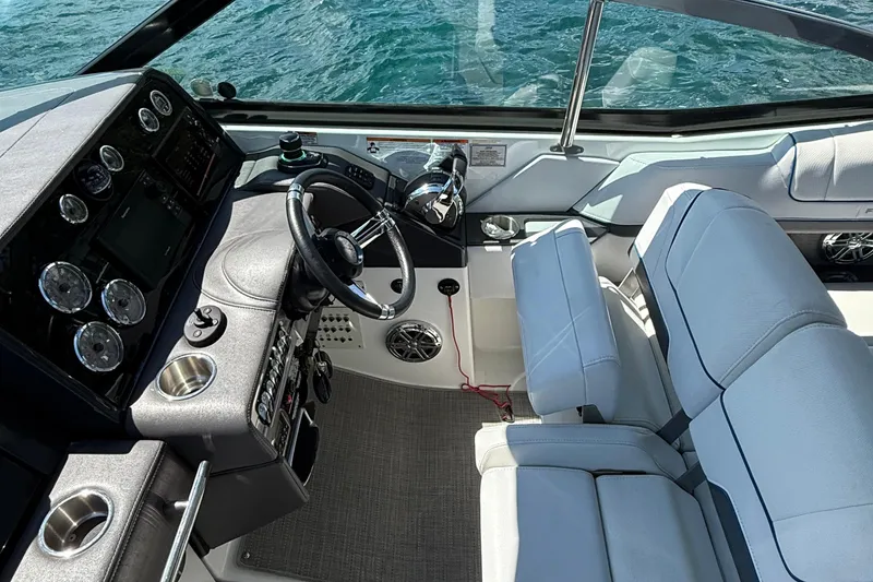 Slide: The Image of 2018 Formula 330 Crossover Bowrider cockpit with steering wheel and control panel, on water. - 7