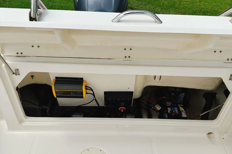 Slide: The Image of 2016 Robalo R222 Center Console boat battery compartment with charger and wiring. - 13