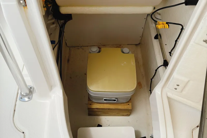 Slide: The Image of 2016 Robalo R222 Center Console boat interior with portable toilet setup. - 19