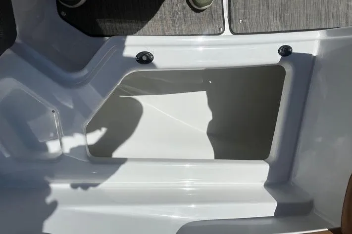 Slide: The Image of 2022 Scarab 215 SE boat interior storage compartment, white and gray design. - 4