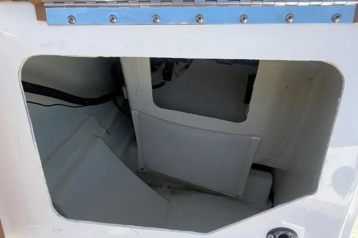Slide: The Image of Storage compartment of a 2022 Scarab 215 SE boat, featuring a hinged access panel. - 5