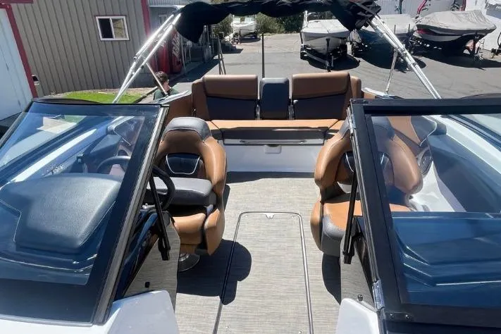 Slide: The Image of 2022 Scarab 215 SE boat interior with brown seating and dual consoles. - 6
