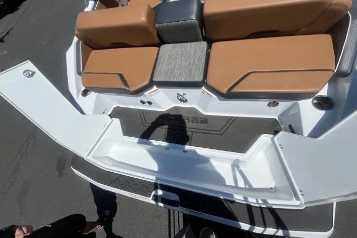 Slide: The Image of 2022 Scarab 215 SE boat interior with tan seating and open storage compartment. - 9