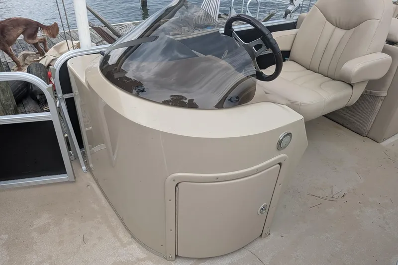 Slide: The Image of 2012 Bennington 2574 GCW boat helm with beige seating and steering wheel. - 10