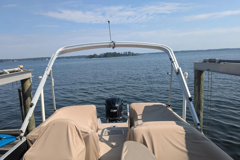 Slide: The Image of 2012 Bennington 2574 GCW pontoon boat docked on a serene lake. - 13