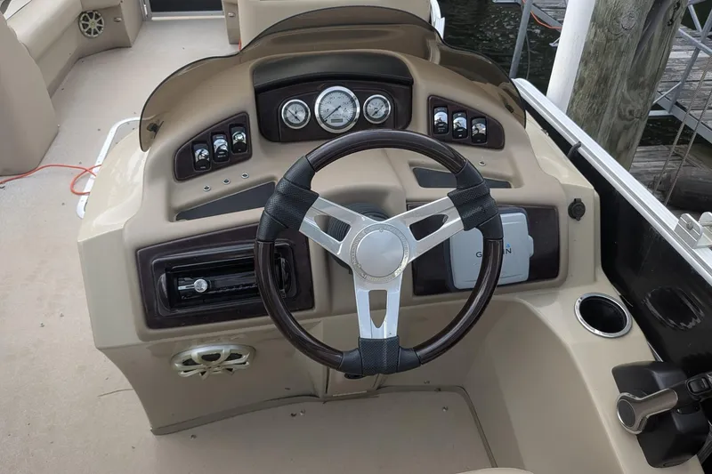 Slide: The Image of Steering console of a 2012 Bennington 2574 GCW boat with gauges and controls. - 2