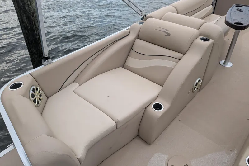 Slide: The Image of Luxurious seating on a 2012 Bennington 2574 GCW boat, featuring beige upholstery and cup holders. - 5