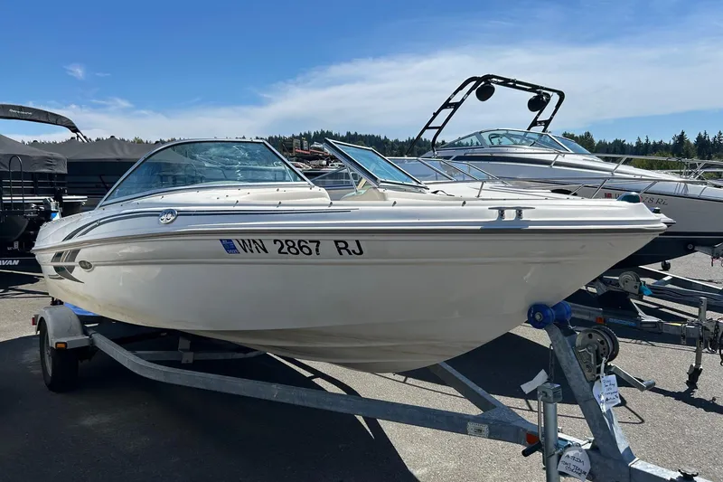 Slide: The Image of 2000 Sea Ray 185 Bow Rider boat on trailer under clear blue sky. - 2
