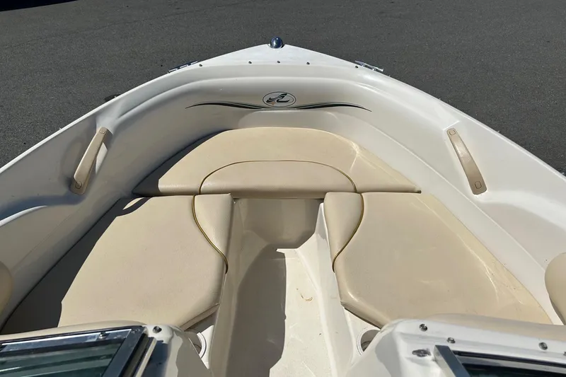 Slide: The Image of 2000 Sea Ray 185 Bow Rider boat interior with beige seating and sleek design. - 3