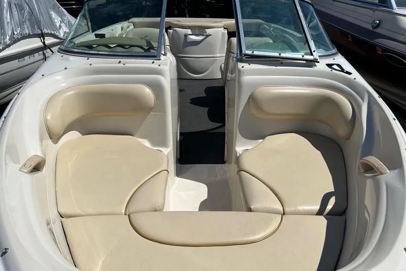 Slide: The Image of 2000 Sea Ray 185 Bow Rider interior with beige seating and open bow layout. - 4