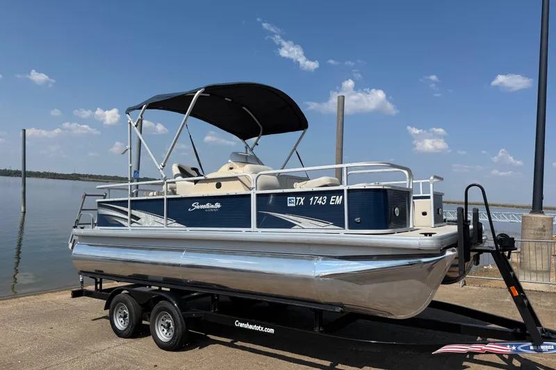 Slide: The Image of 2018 Sweetwater Sunrise 206 F pontoon boat on trailer by a lake. - 0