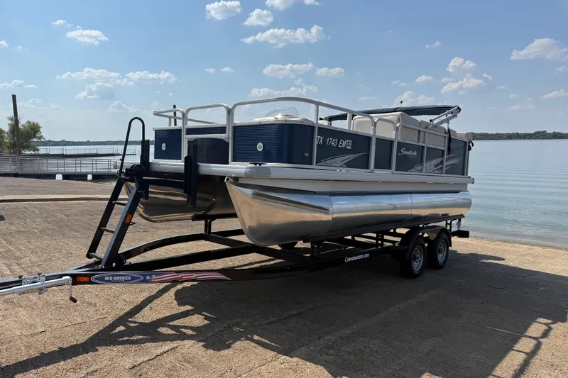 Slide: The Image of 2018 Sweetwater Sunrise 206 F pontoon boat on trailer by a lake. - 1