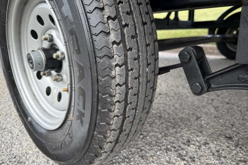 Slide: The Image of 2018 Sweetwater Sunrise 206 F pontoon boat on trailer, blue and silver design, sunny day. - 12