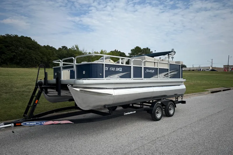 Slide: The Image of 2018 Sweetwater Sunrise 206 F pontoon boat on trailer by a lake. - 2