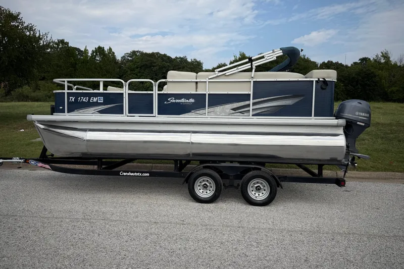 Slide: The Image of 2018 Sweetwater Sunrise 206 F pontoon boat on trailer by a lake under blue sky. - 8