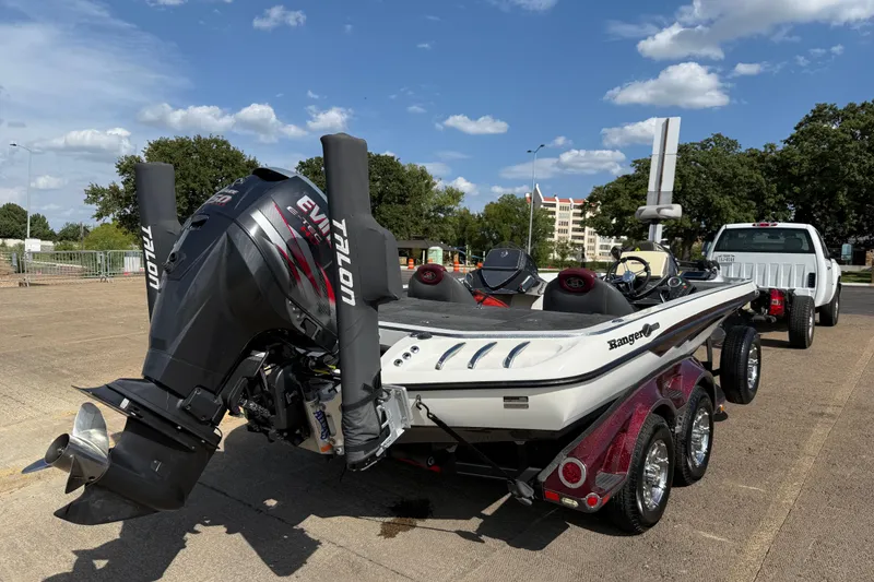Slide: The Image of 2014 Ranger Z520 Comanche boat on trailer, parked near a white truck under a clear sky. - 10