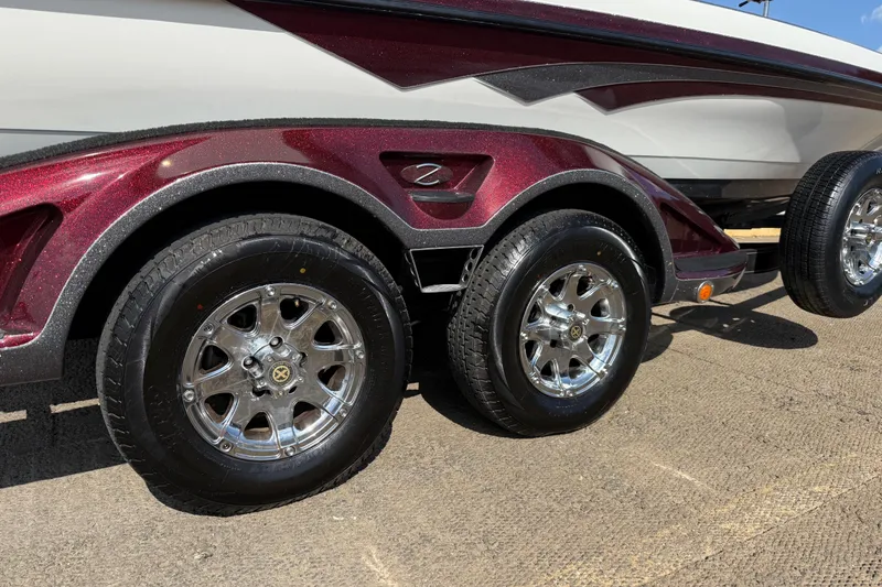 Slide: The Image of 2014 Ranger Z520 Comanche boat on trailer by a lakeside dock under a cloudy sky. - 16