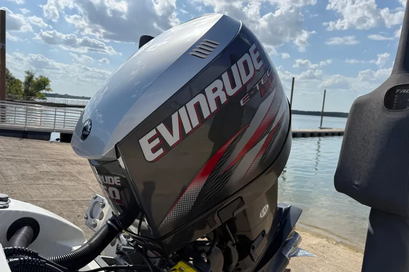 Slide: The Image of 2014 Ranger Z520 Comanche boat parked near a waterfront under a clear blue sky. - 39