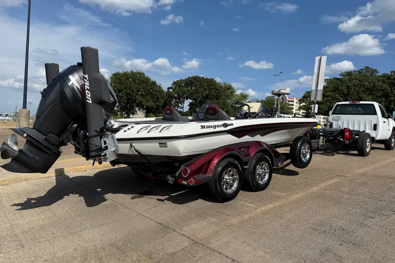 Slide: The Image of 2014 Ranger Z520 Comanche boat on trailer, parked near a lake under a clear sky. - 9