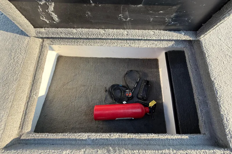 Slide: The Image of Storage compartment of 2008 Bee Line 286 Pro Vee with fire extinguisher and cables. - 35