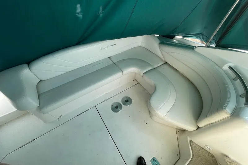 Slide: The Image of 1999 Silverton 360 Express boat interior with white leather seating and green canopy. - 10