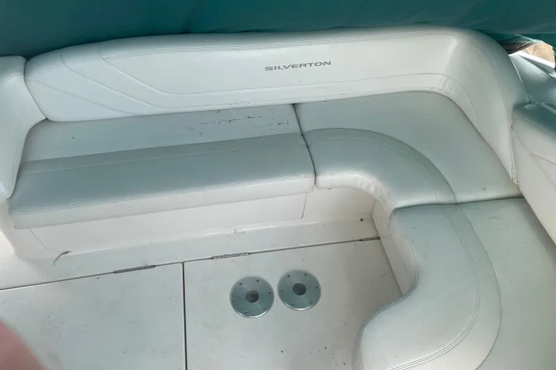 Slide: The Image of 1999 Silverton 360 Express boat interior with white cushioned seating. - 11
