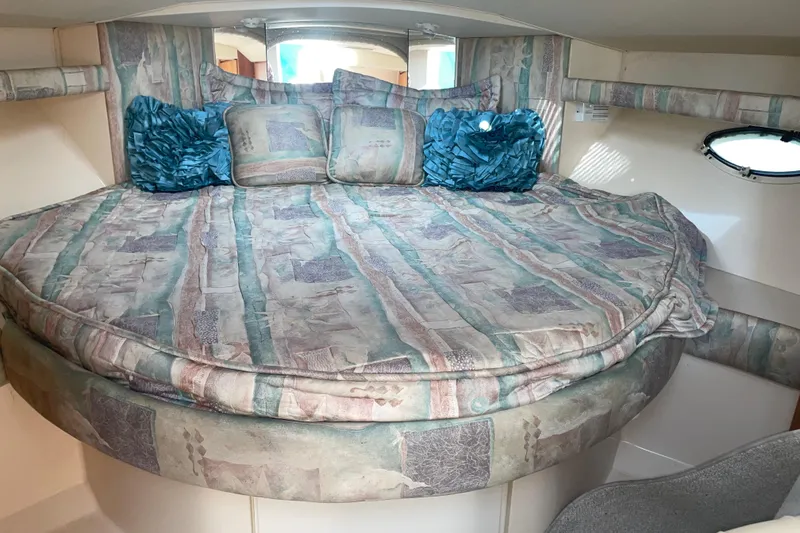 Slide: The Image of 1999 Silverton 360 Express cabin with patterned bedding and decorative pillows. - 15