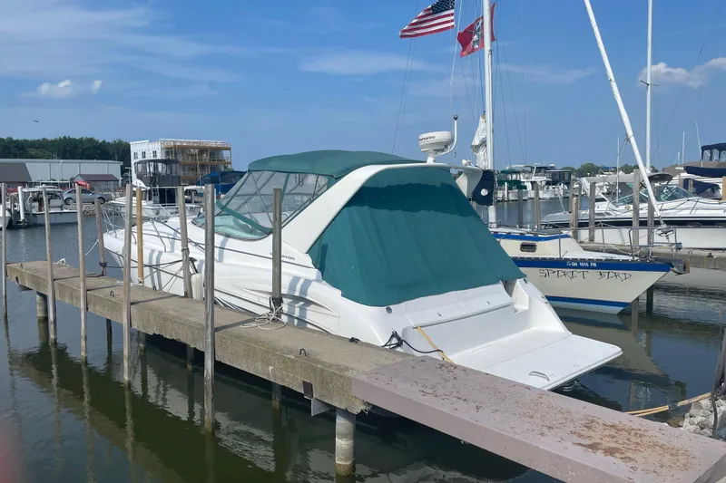 Slide: The Image of 1999 Silverton 360 Express docked at marina with flags and boats in background. - 2