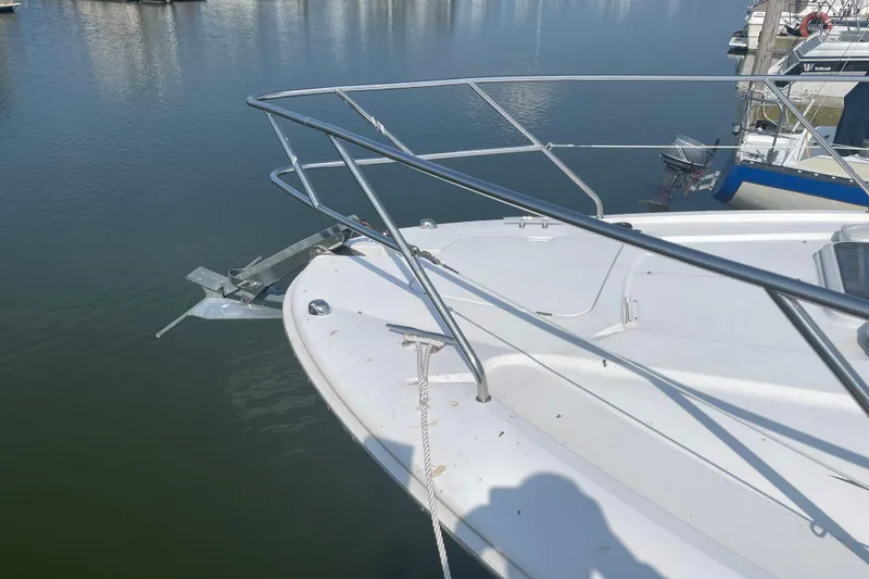 Slide: The Image of 1999 Silverton 360 Express yacht bow with anchor, docked on calm water. - 4