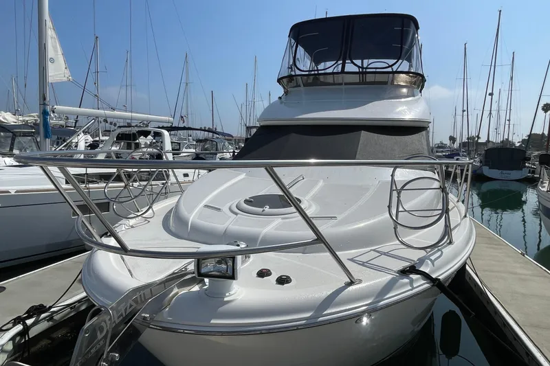 Slide: The Image of 2008 Meridian 341 Sedan yacht docked at marina, surrounded by sailboats under clear sky. - 2