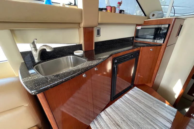 Slide: The Image of 2008 Meridian 341 Sedan yacht kitchen with sink, microwave, and wooden cabinetry. - 21