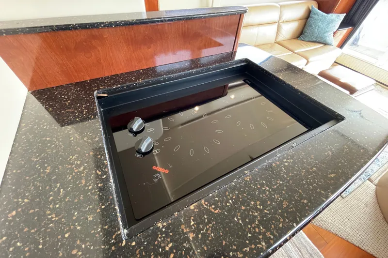 Slide: The Image of Luxury yacht interior with sleek black cooktop, granite countertop, and leather seating in a 2008 Meridian 341 Sedan. - 24