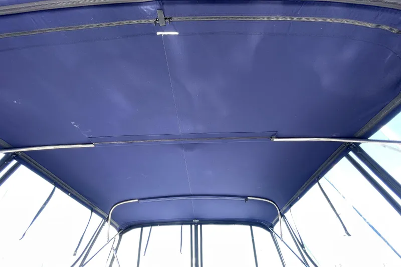 Slide: The Image of Blue canopy of a 2008 Meridian 341 Sedan boat, featuring metal support frames. - 52
