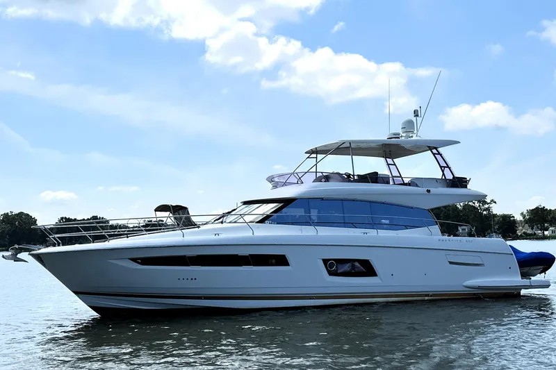 The Image of Luxury 2016 Prestige 550 yacht cruising on a scenic waterfront. - 0