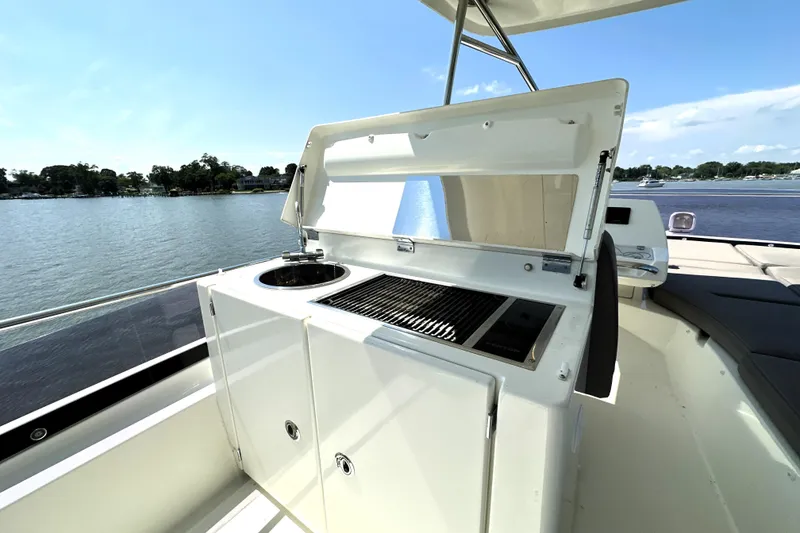 Slide: The Image of 2016 Prestige 550 yacht with sunbathing deck, docked in a marina under clear blue skies. - 22