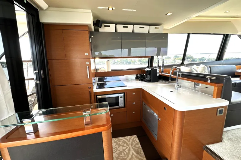 Slide: The Image of Luxurious 2016 Prestige 550 yacht interior with spacious seating, docked at a scenic marina. - 26