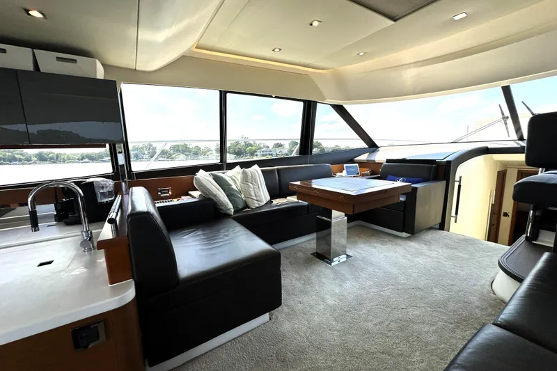 Slide: The Image of 2016 Prestige 550 yacht deck with seating, overlooking marina and blue sky. - 31