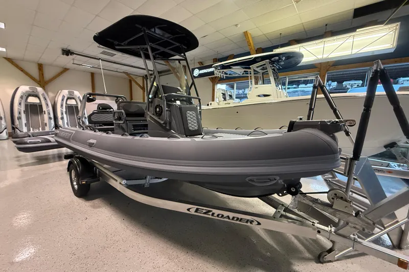 Slide: The Image of 2026 Highfield Sport 560 boat on trailer in showroom, featuring sleek design and modern features. - 10